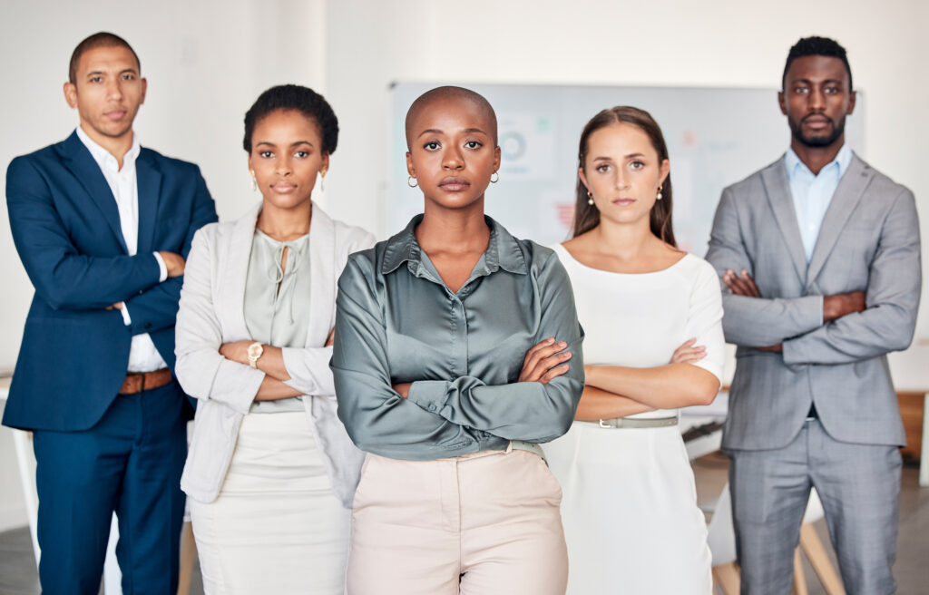 Zwei Männer und drei Frauen stehen mit verschränkten Armen und im Business-Outfit und schauen in die Kamera