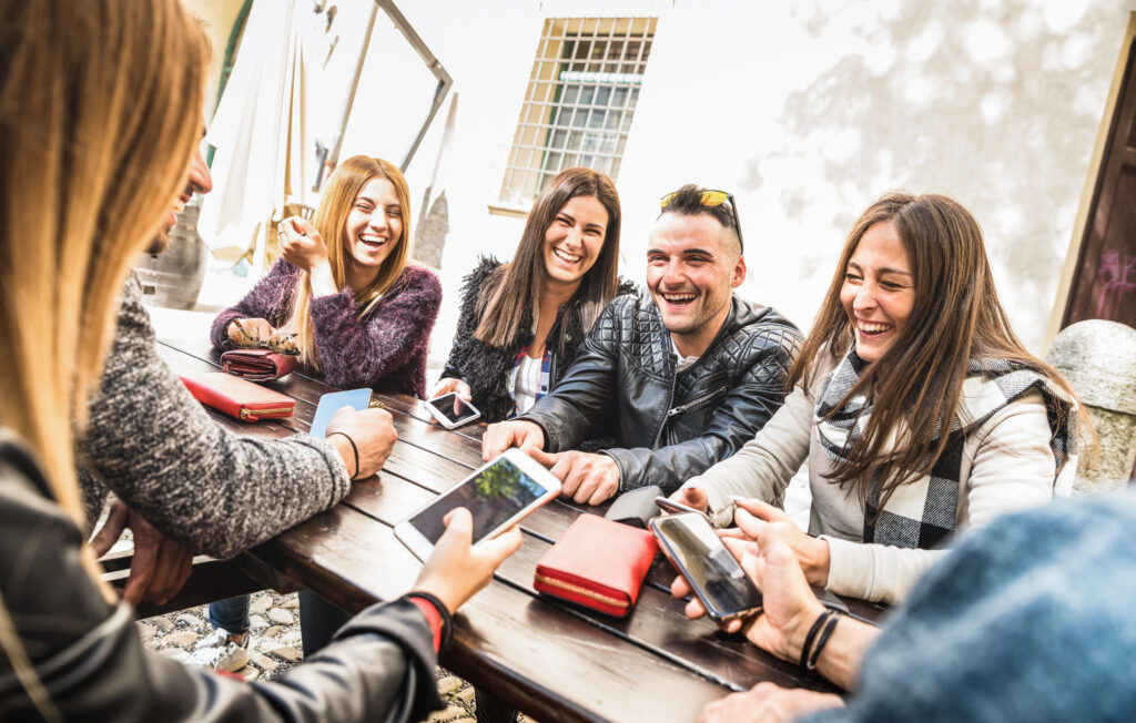 Eine Gruppe von Millennials sitzen an einem Tisch