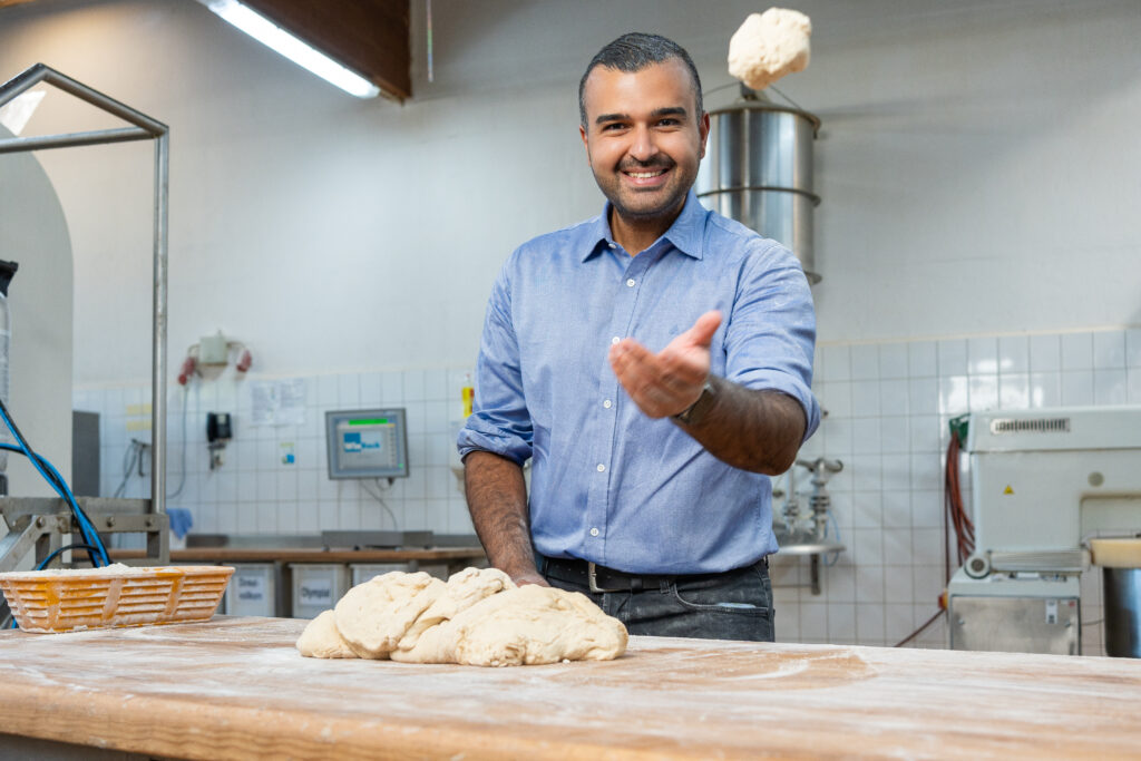 Eyüp Aramaz steht vor Teigling in einer Backstube