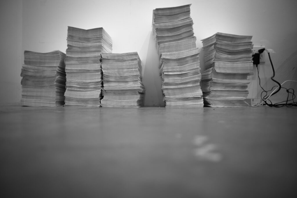 Fünf hohe Zeitungsstapeln 