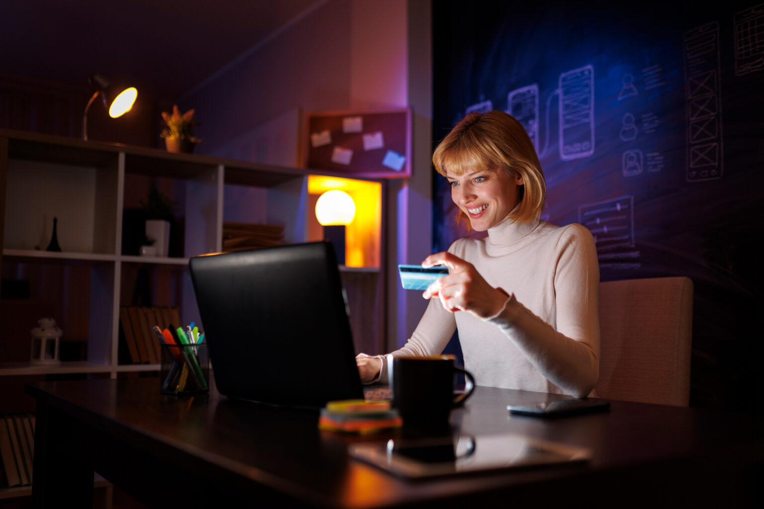 Frau shoppt online über einen Laptop und hält Kreditkarte in der Hand