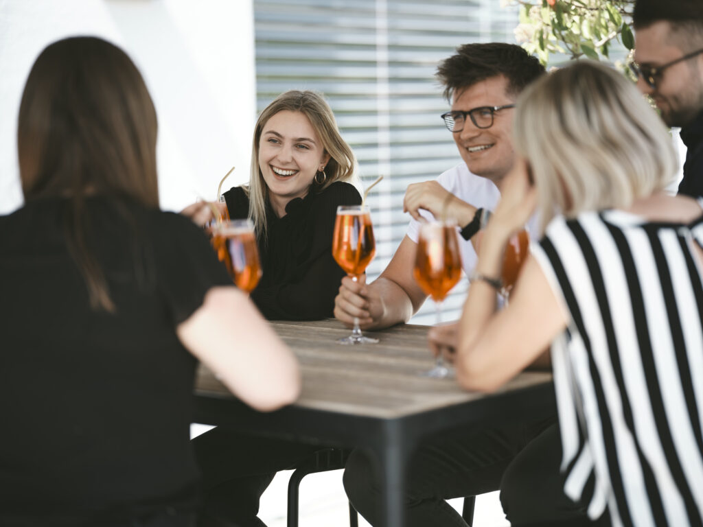 Mitarbeiter sitzen bei einem After-Work-Drink zusammen.