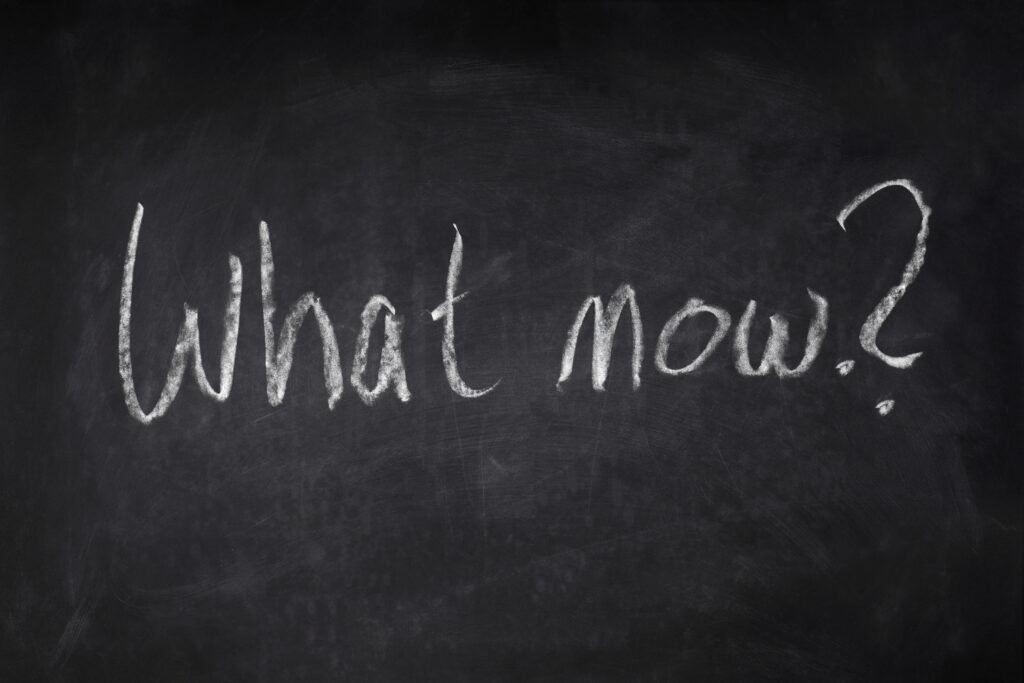 Schwarze Tafel mit der Aufschrift: What now?