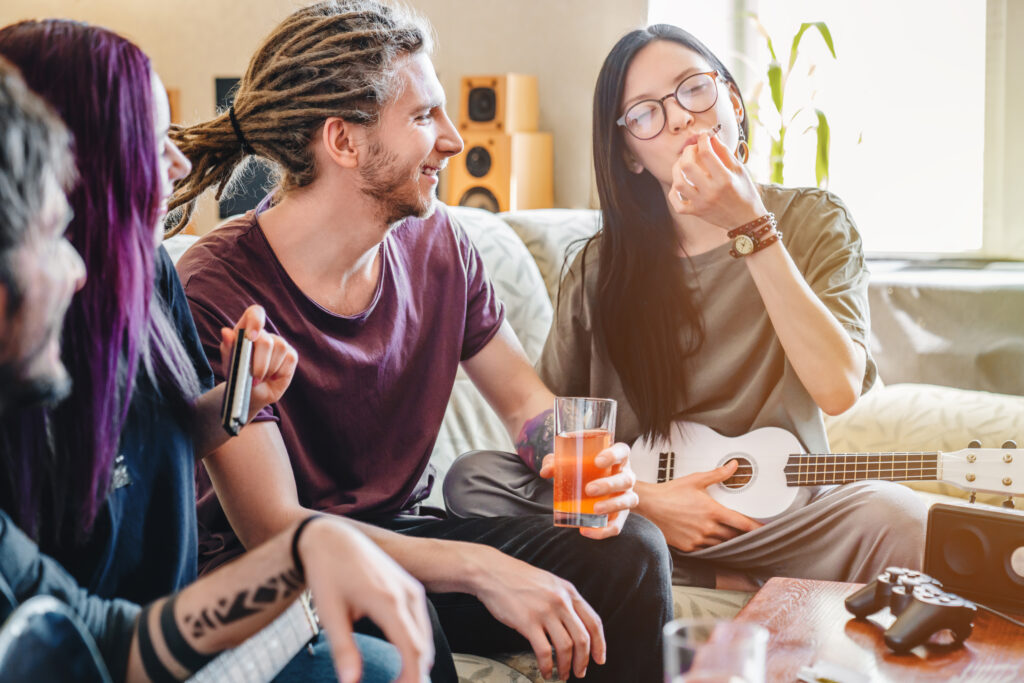 Drei Personen rauchen Cannabis und trinken Alkohol