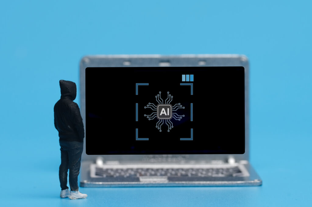 Blauer Hintergrund. Davor ein PC mit AI auf dem Bildschirm und ein Mann von hinten in schwarzer Kleidung und weißen Turncshuhen