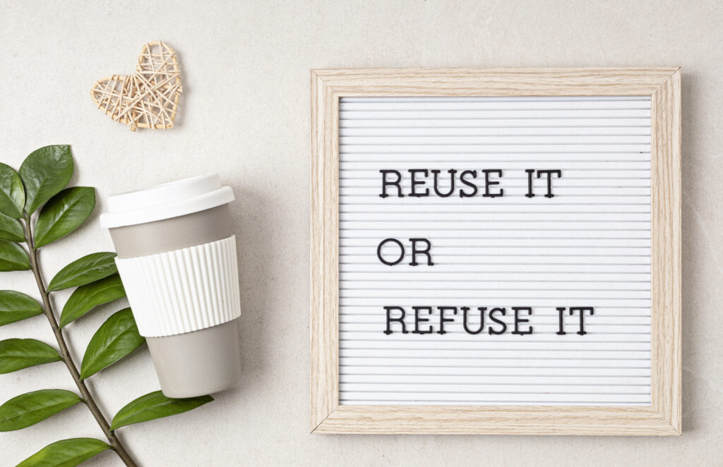Reuse it or refuse it Schild neben einem Kaffeebecher
