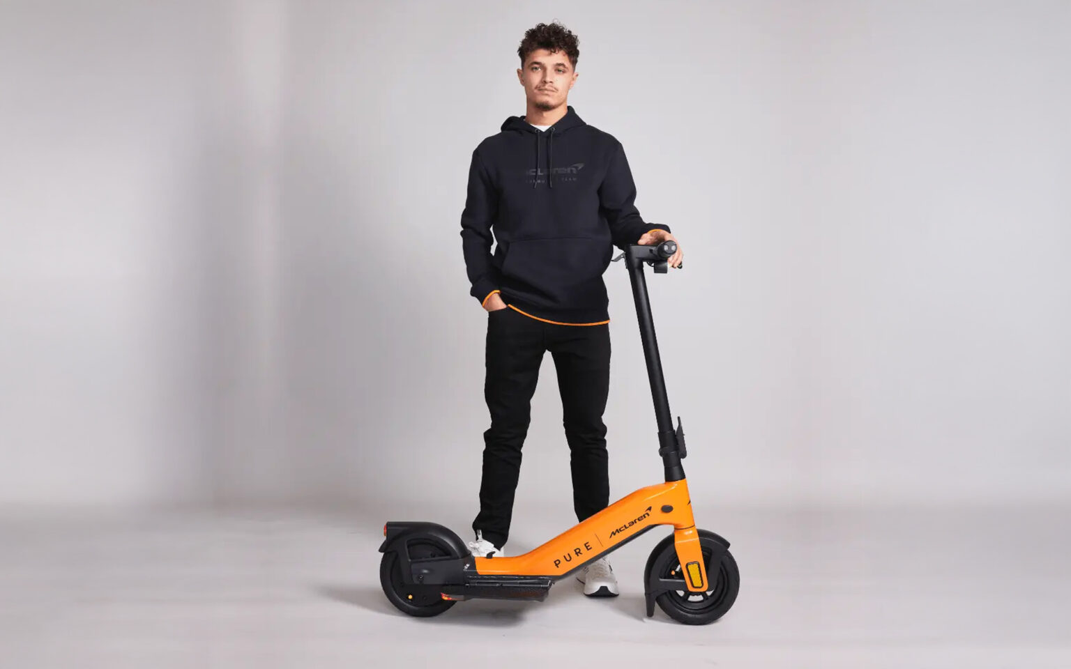 Lando Norris posiert mit E-Scooter