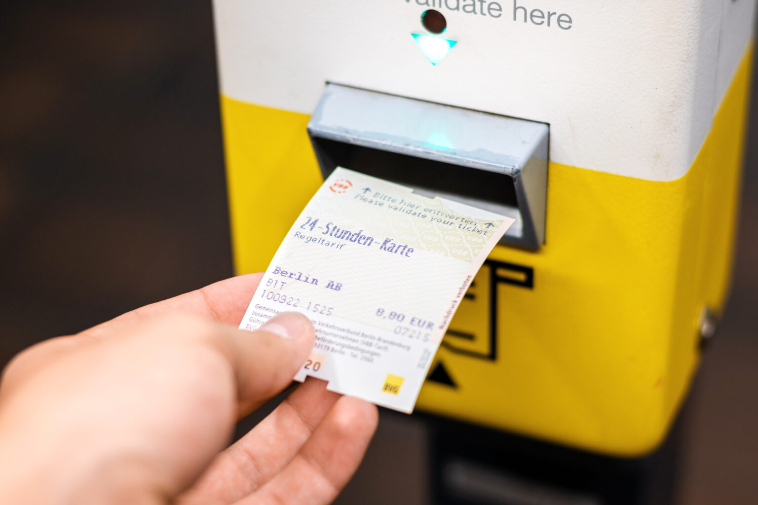 Ticket das von einer Hand aus dem Automat gezogen wird